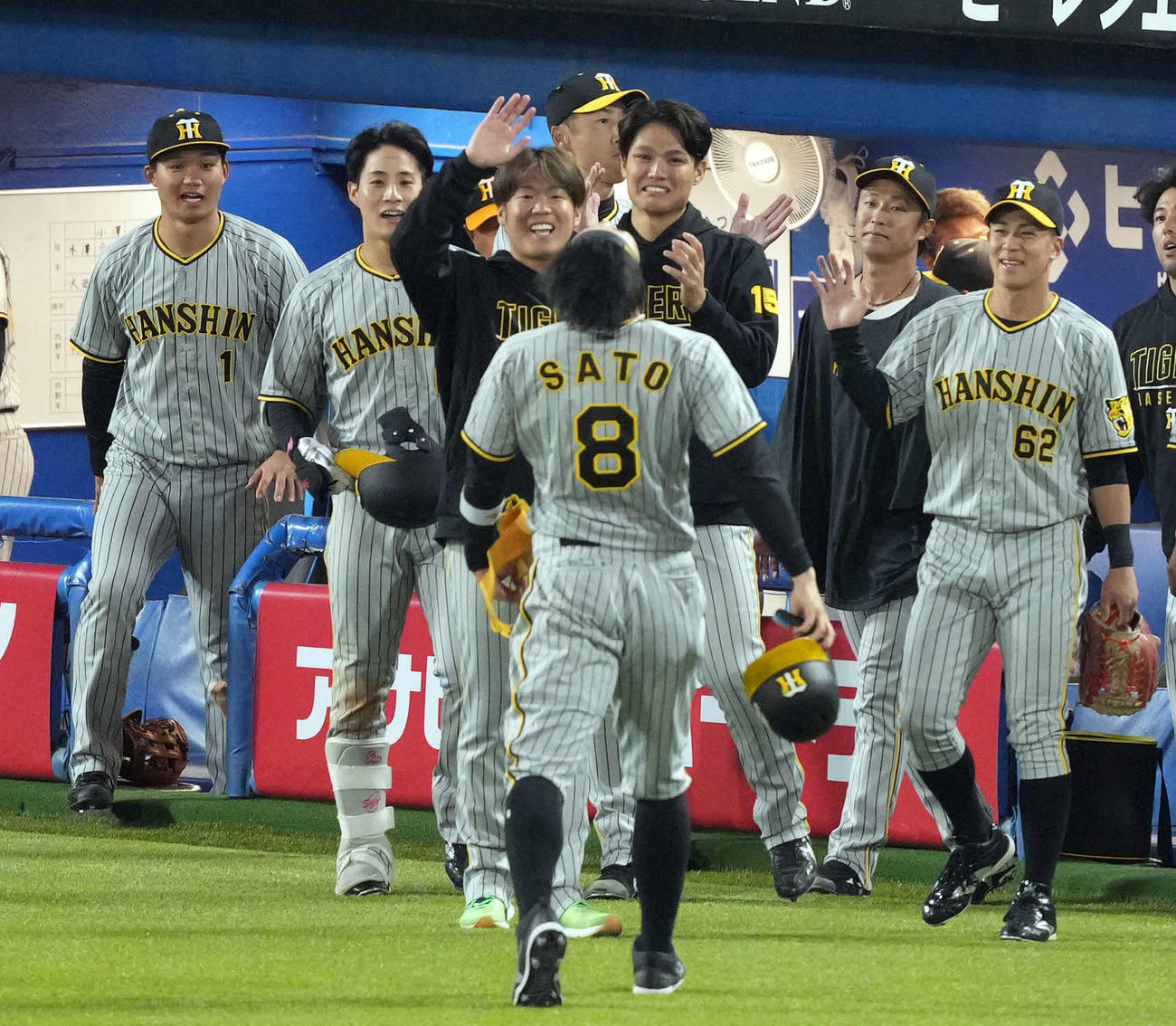 ヤクルト対阪神　9回表を終え、この回に逆転2点適時二塁打を放った佐藤輝（手前）を迎えるチームメートたち（撮影・狩俣裕三）