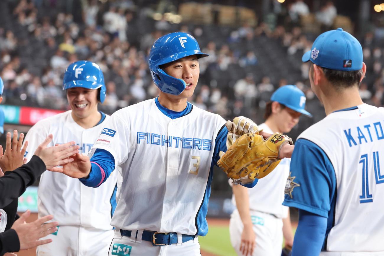 日本ハム対ソフトバンク　2回裏、生還しナインに出迎えられる加藤豪（撮影・黒川智章）