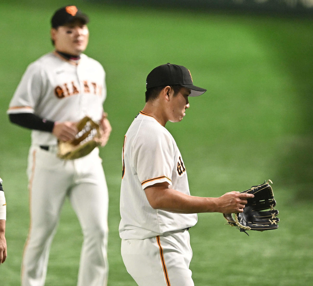 巨人対日本ハム　1回を投げ終えた巨人先発の菅野（手前）は厳しい表情で引き揚げる（2023年3月18日撮影）