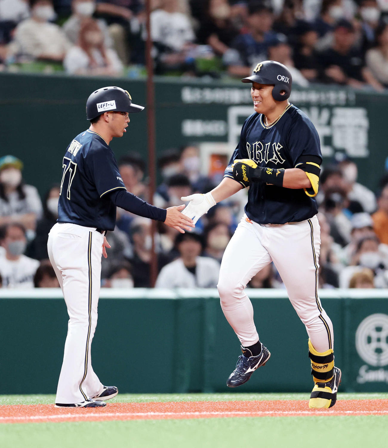 西武対オリックス　3回表オリックス無死、杉本（右）は中越えソロ本塁打を放ち梵コーチと笑顔でタッチ（撮影・鈴木正人）