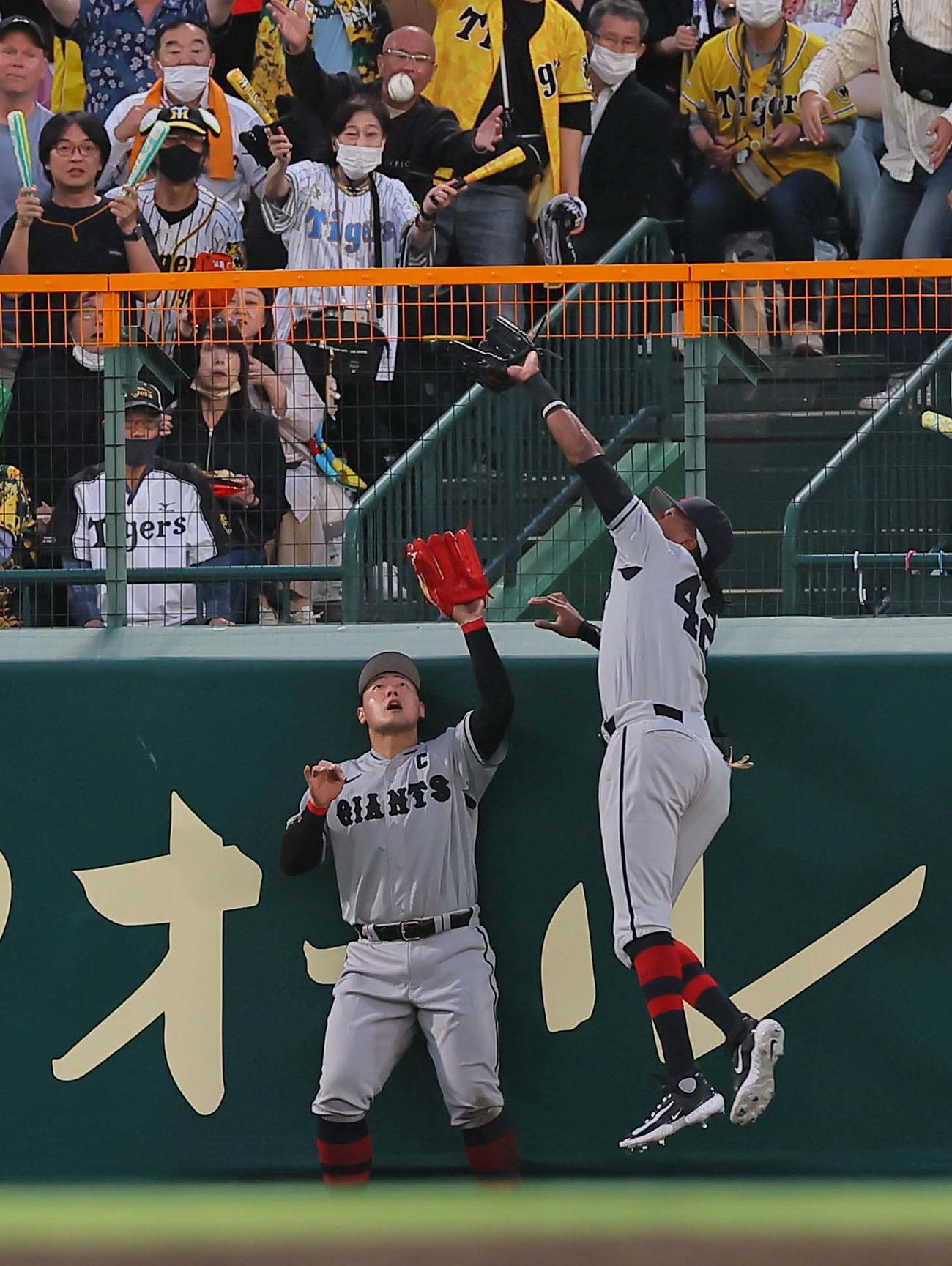 阪神対巨人　4回裏阪神2死一塁、大山の中飛を追い交錯する中堅手のブリンソン（右）と左翼手の岡本（撮影・上田博志）