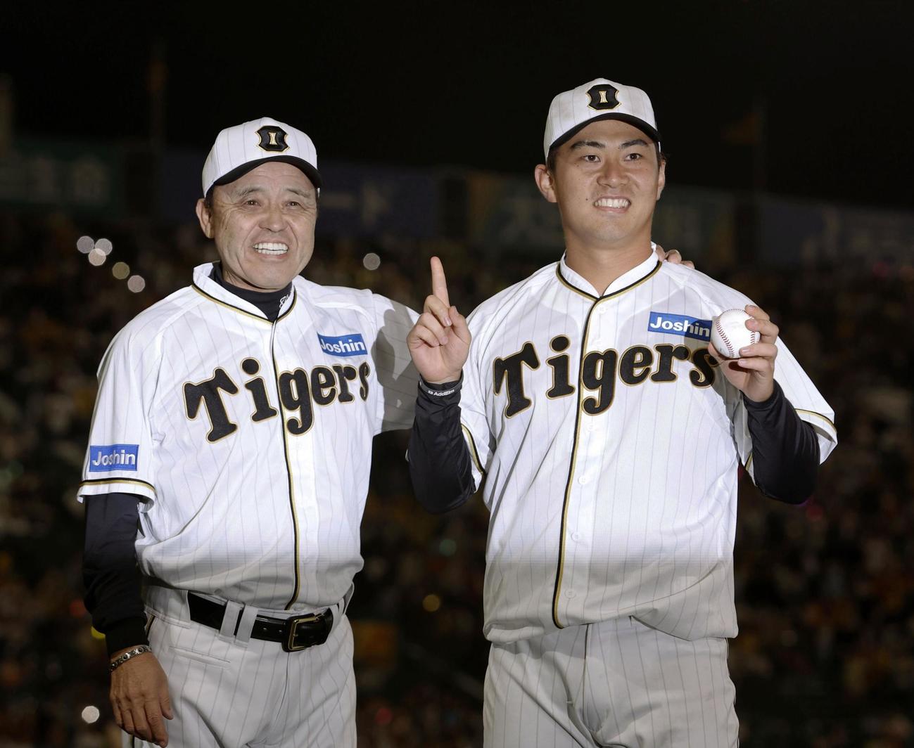プロ初勝利を挙げ、ウイニングボールを手に岡田監督（左）とポーズをとる阪神・桐敷（共同）