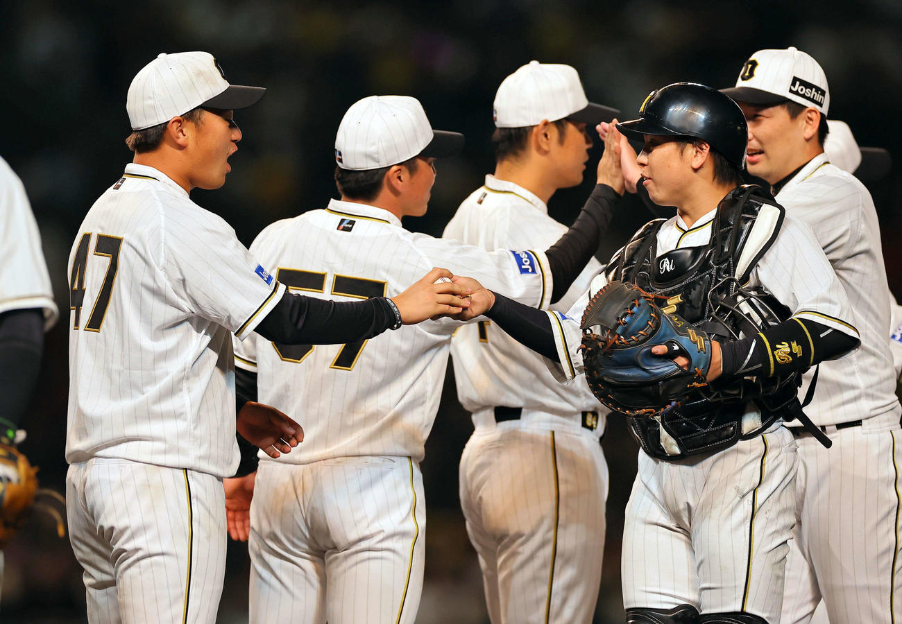 阪神対巨人　プロ初勝利を挙げた桐敷（左）は梅野から勝利球を受け取る（撮影・上田博志）