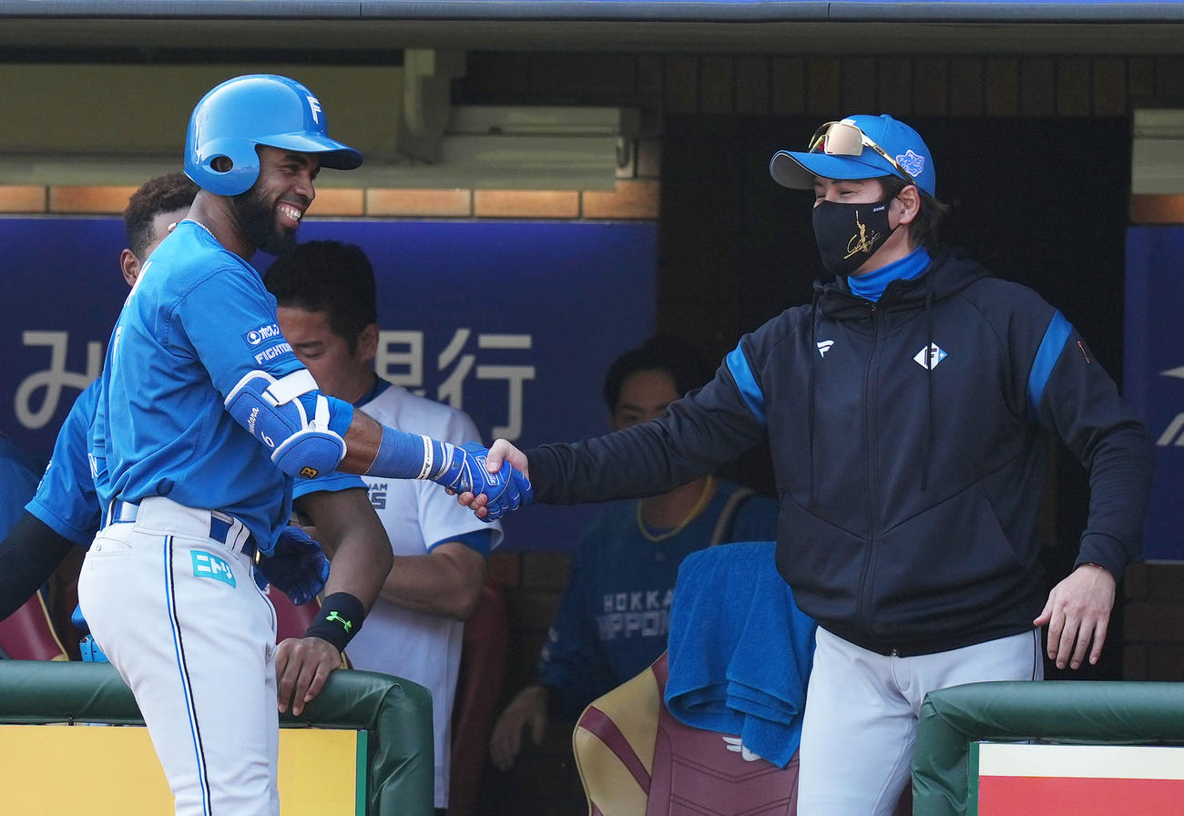 楽天対日本ハム　7回表日本ハム無死一塁、投犠打を決めたアルカンタラ（左）と握手を交わす新庄監督（撮影・横山健太）