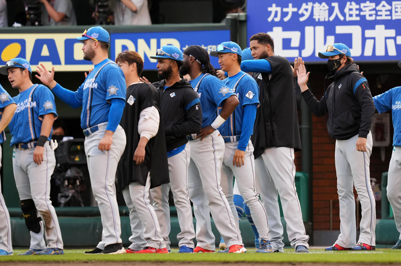 楽天対日本ハム　楽天に勝利しナインとタッチを交わす日本ハム新庄監督（右）（撮影・横山健太）