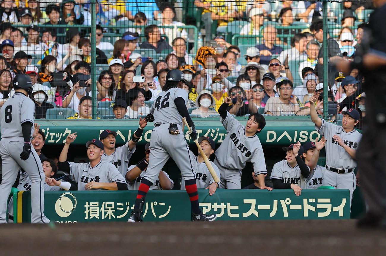 阪神対巨人　9回表巨人2死一塁、2点本塁打を放ったブリンソン（中央）をベンチで出迎える巨人ナイン（撮影・上田博志）