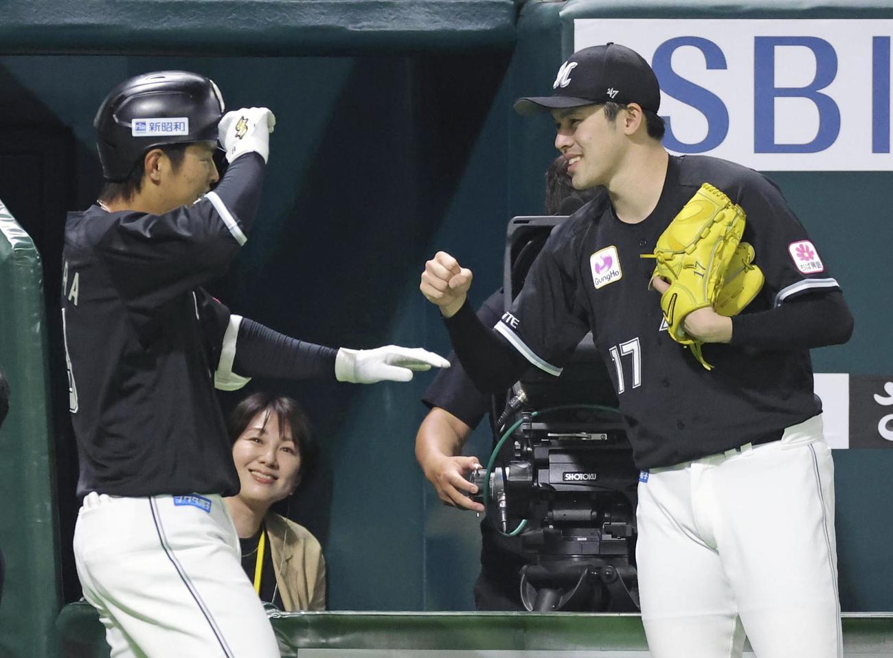 1回、先制2ランを放った中村奨吾（左）を迎えるロッテ・佐々木朗希（共同）