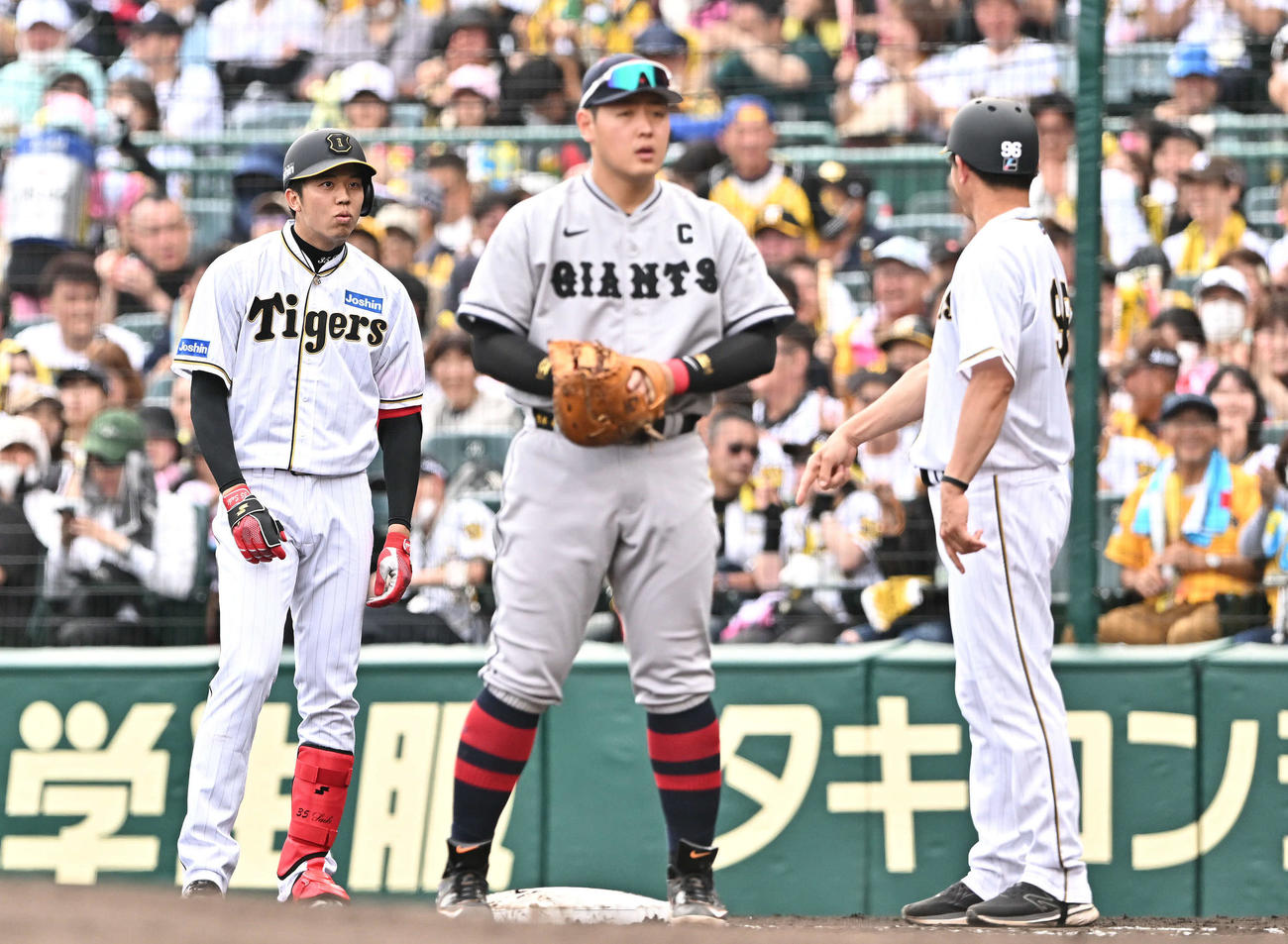 阪神対巨人　5回裏阪神無死、才木（左）は投手内野安打となり驚いた表情を見せる。一塁手岡本和（撮影・滝沢徹郎）