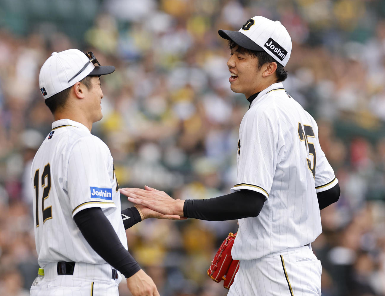 阪神対巨人　8回表巨人2死一塁、降板し坂本（左）と笑顔でタッチを交わす阪神才（撮影・藤尾明華）
