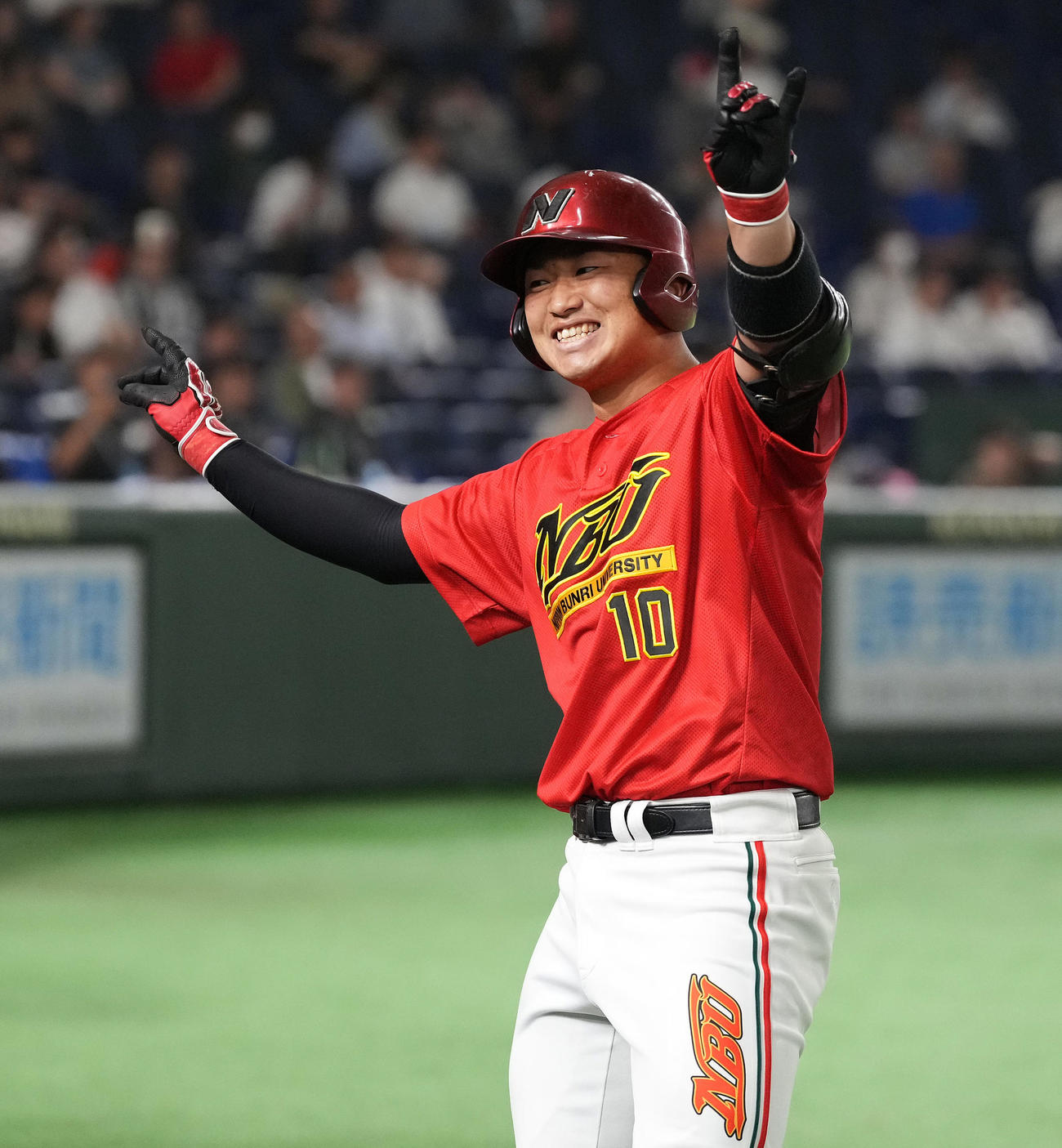 中部学院大対日本文理大　3回裏日本文理大2死一、二塁、左中間に3点本塁打を放った飯塚はベンチ前でポーズ（撮影・鈴木みどり）