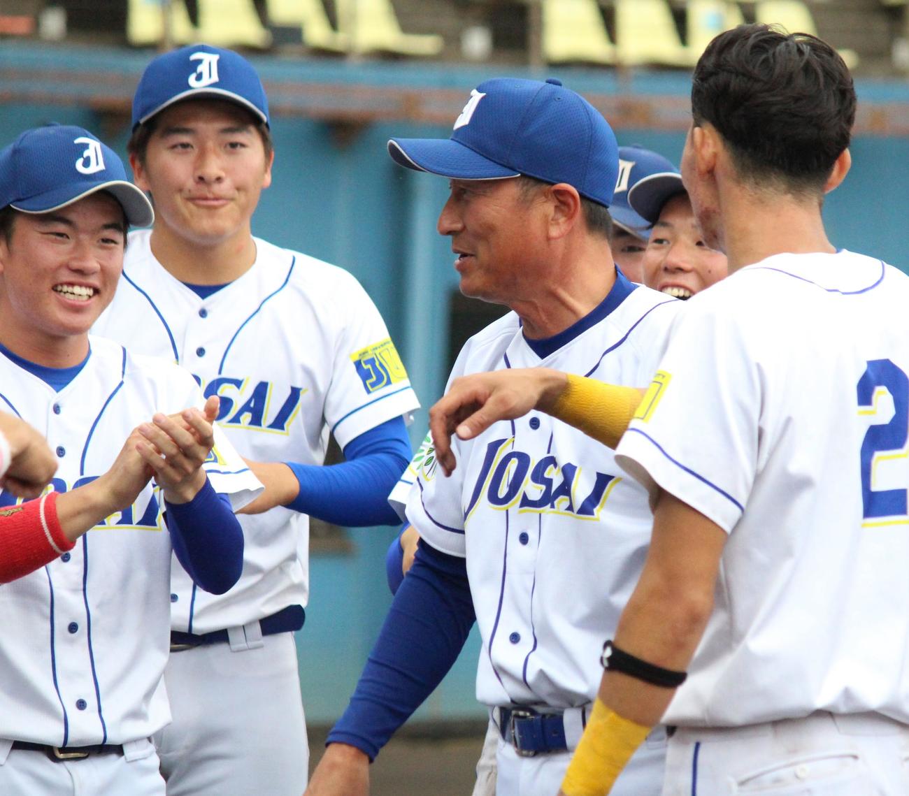 武蔵大対城西大　試合後、選手に囲まれて笑顔を見せる城西大・村上監督（左から3人目）（撮影・保坂恭子）