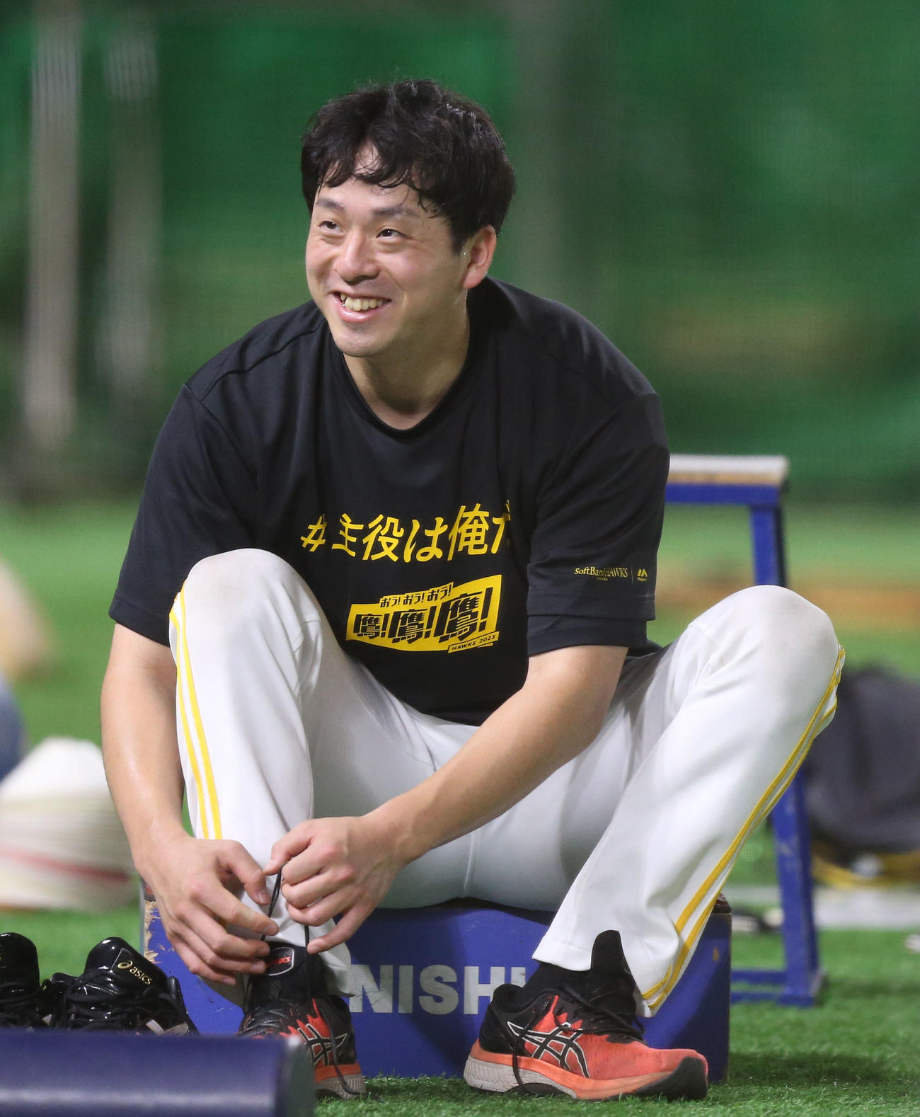 笑顔で靴紐を結ぶ大関（撮影・冨田成美）