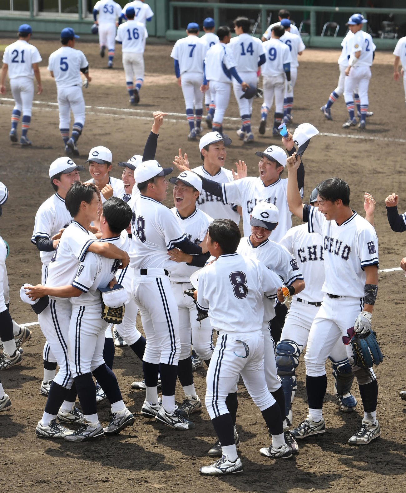 中大対駒大　駒大を破り1部残留を決めた中大ナインは大喜びする。後方は敗れた駒大ナイン（撮影・柴田隆二）