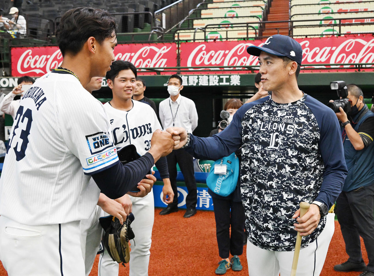 西武対阪神　試合前練習に参加した西武古川（左）は松井監督（右）とグータッチする（撮影・滝沢徹郎）