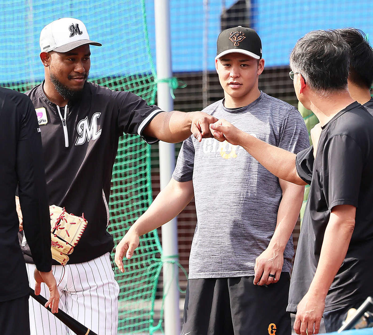 巨人スタッフらとの再会に笑顔を見せるロッテのメルセデス（左）（撮影・足立雅史）