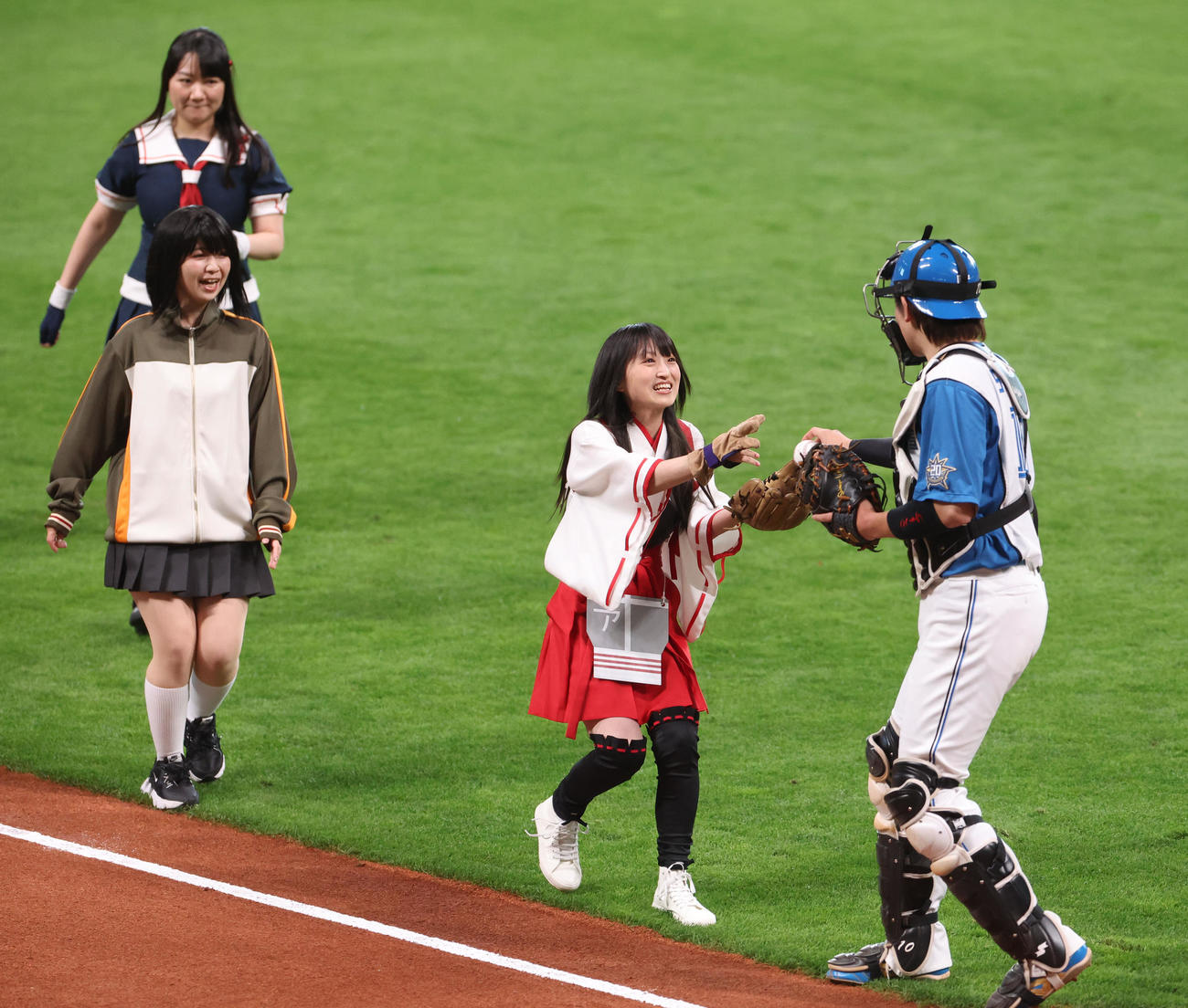 日本ハム対ヤクルト　試合前、始球式を務めた藤田咲さんは清水優心からボールを受けとる（撮影・佐藤翔太）