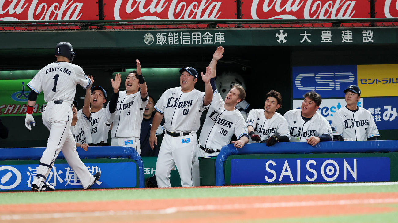 4回裏西武無死、右越えソロ本塁打を放った栗山（左）をベンチのナインが出迎える（撮影・加藤哉）
