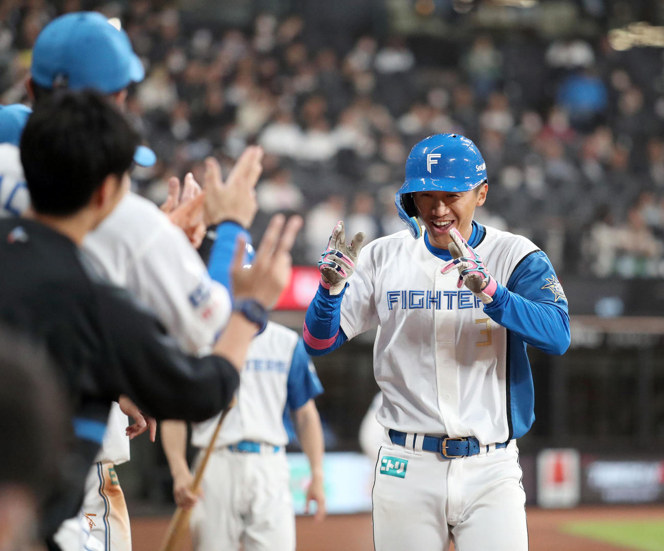 日本ハム対ヤクルト　5回裏日本ハム2死、右越え本塁打を放ちナインに出迎えられポーズをとる加藤豪（撮影・佐藤翔太）