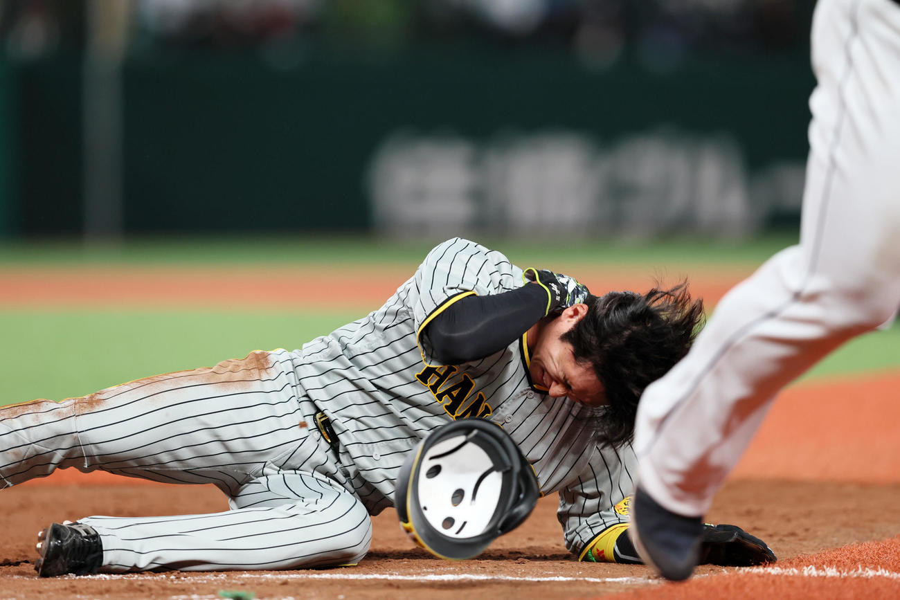 5回表阪神2死一塁、一塁走者近本は森脇のけん制球で帰塁したとき一塁手渡部と接触し首筋を痛める（撮影・加藤哉）
