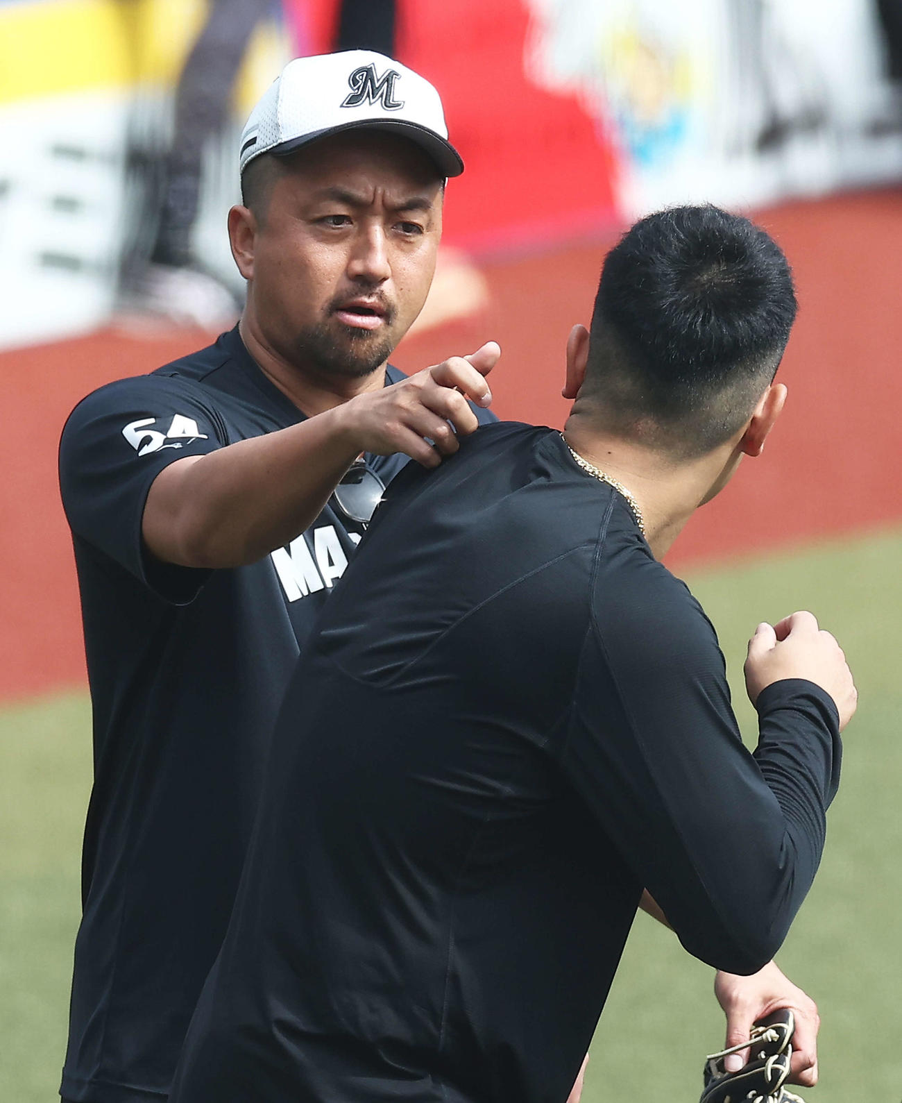 ロッテ対巨人　試合前、巨人岡本和（手前）に接近するロッテ沢村（撮影・河田真司）