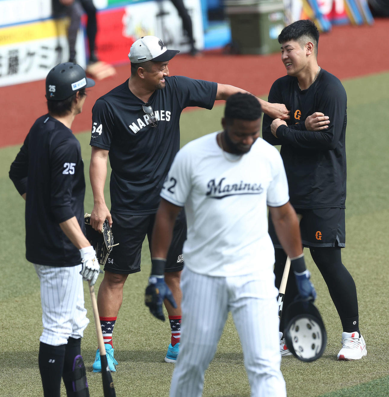 ロッテ対巨人　試合前、巨人岡本和（右）に笑顔であいさつするロッテ沢村（撮影・河田真司）