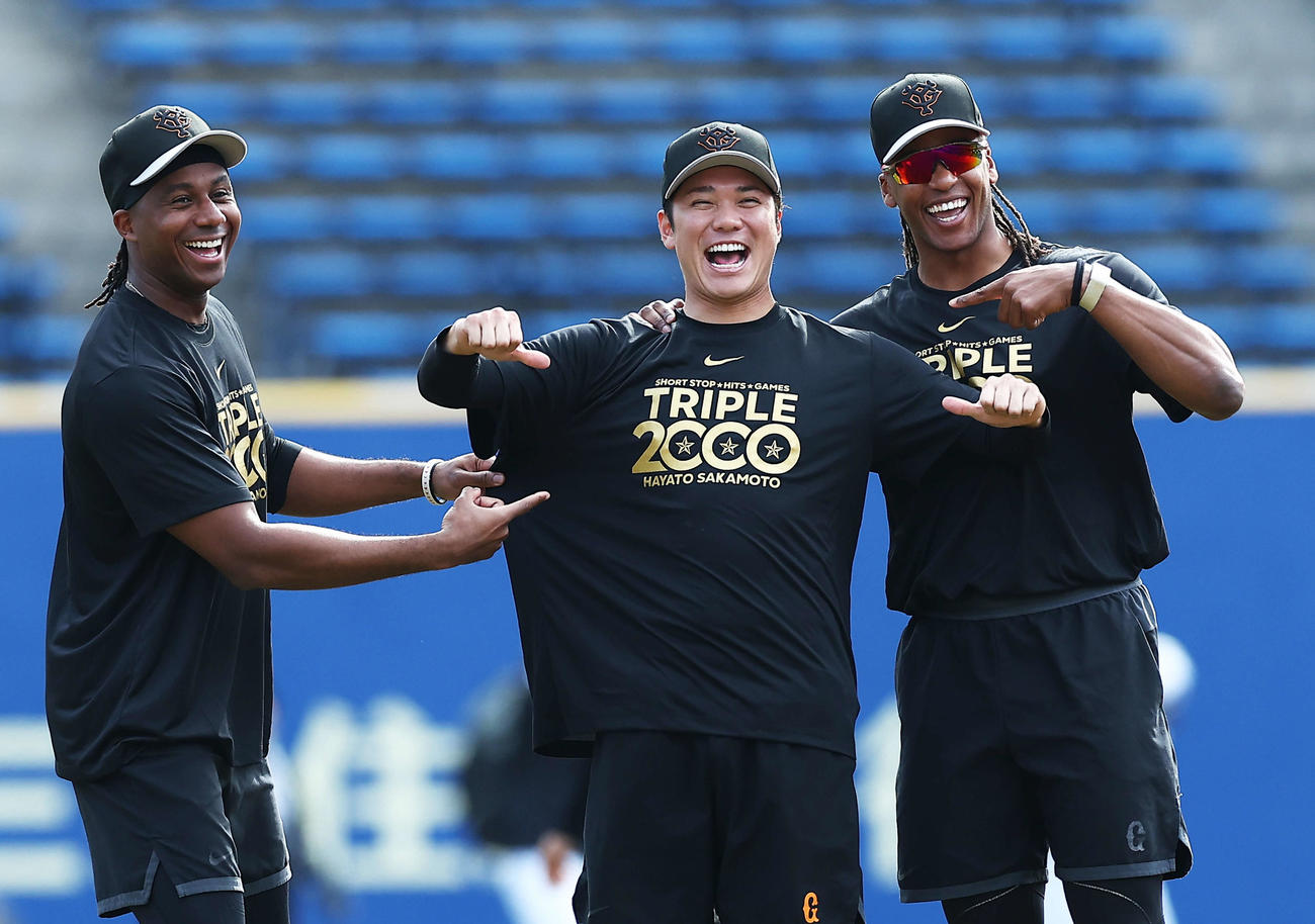 ロッテ対巨人　試合前、記念Tシャツを指さすブリンソン（左）とウォーカーに囲まれ笑顔を見せる巨人坂本（撮影・河田真司）