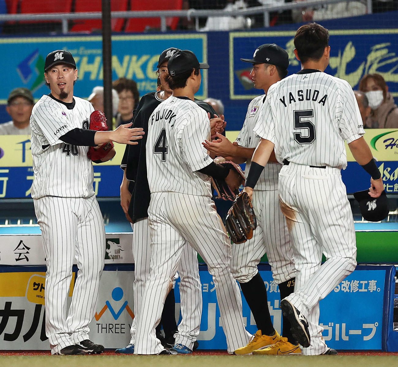 ロッテ対巨人　8回表を抑え、ナインを迎える西村（左）（撮影・河田真司）