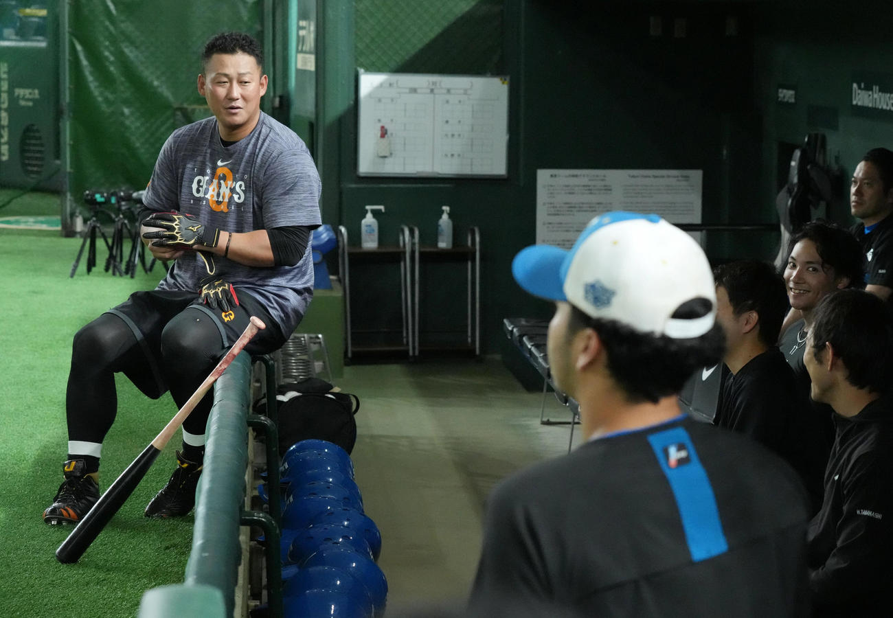 試合前の練習で三塁側ベンチの日本ハムナインと談笑する巨人中田翔（左）（撮影・小沢裕）