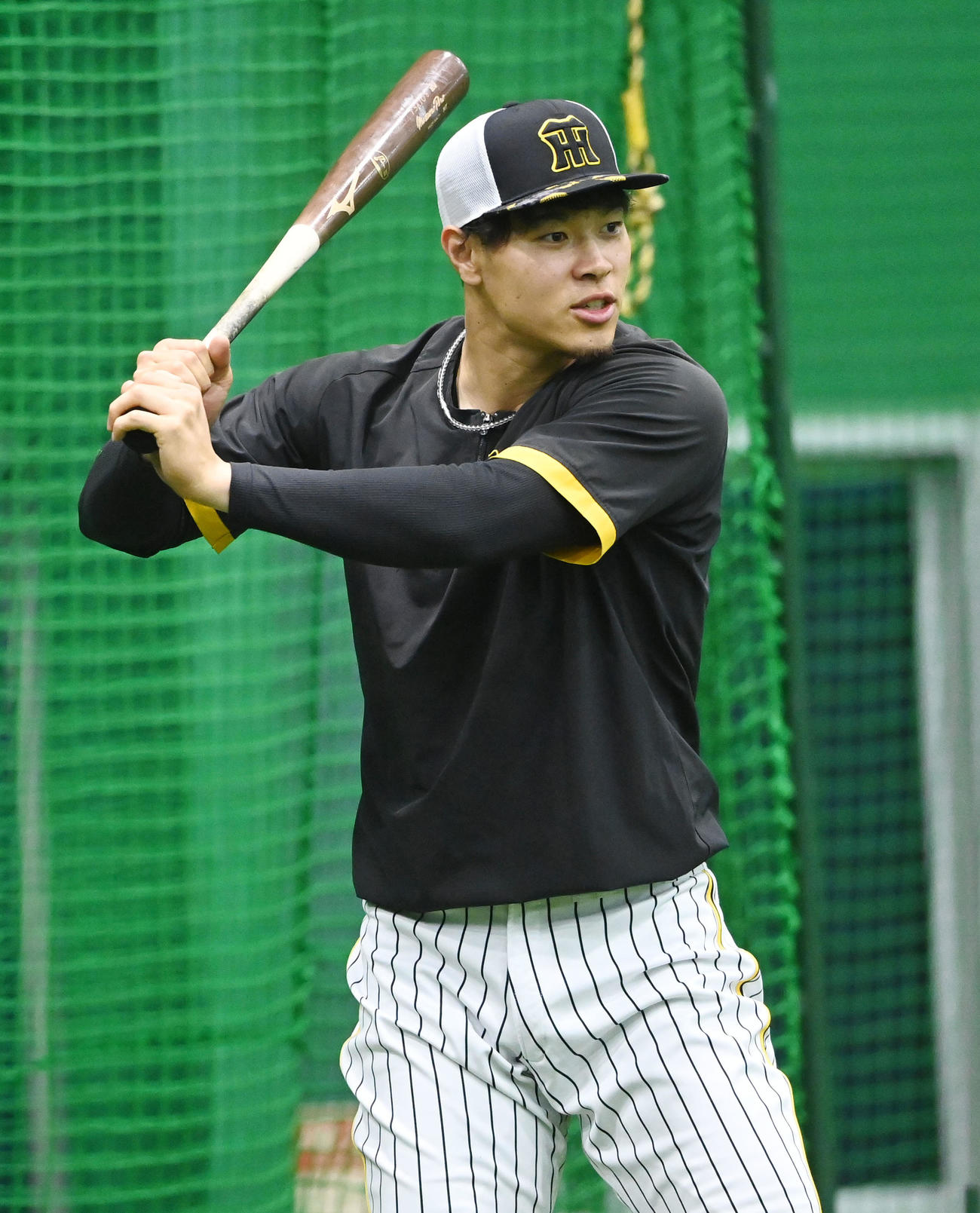 室内練習場で打撃の準備をする阪神佐藤輝（撮影・和賀正仁）