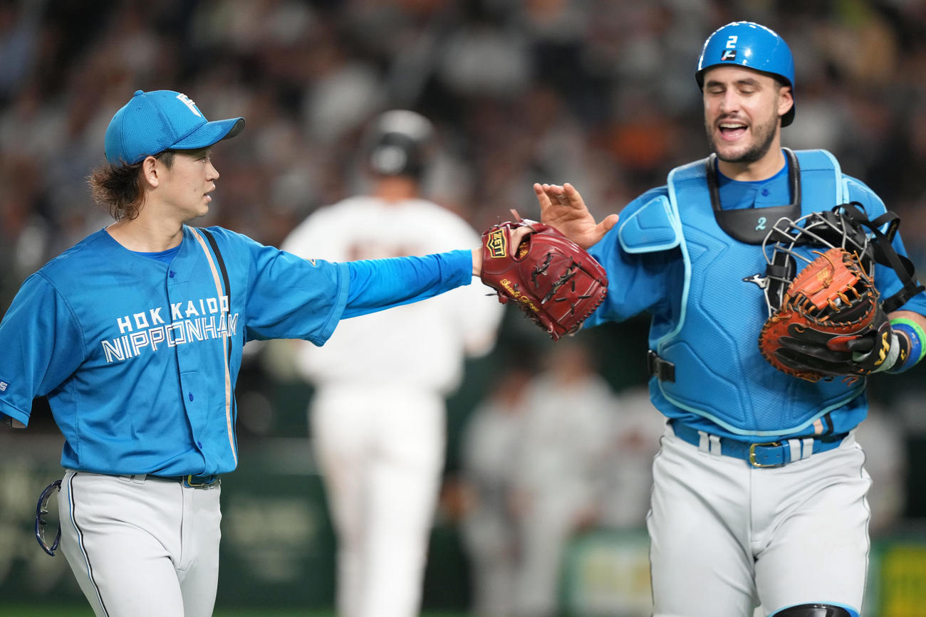 巨人対日本ハム　5回裏を終え、マルティネス（右）とタッチを交わす日本ハム鈴木（撮影・鈴木みどり）