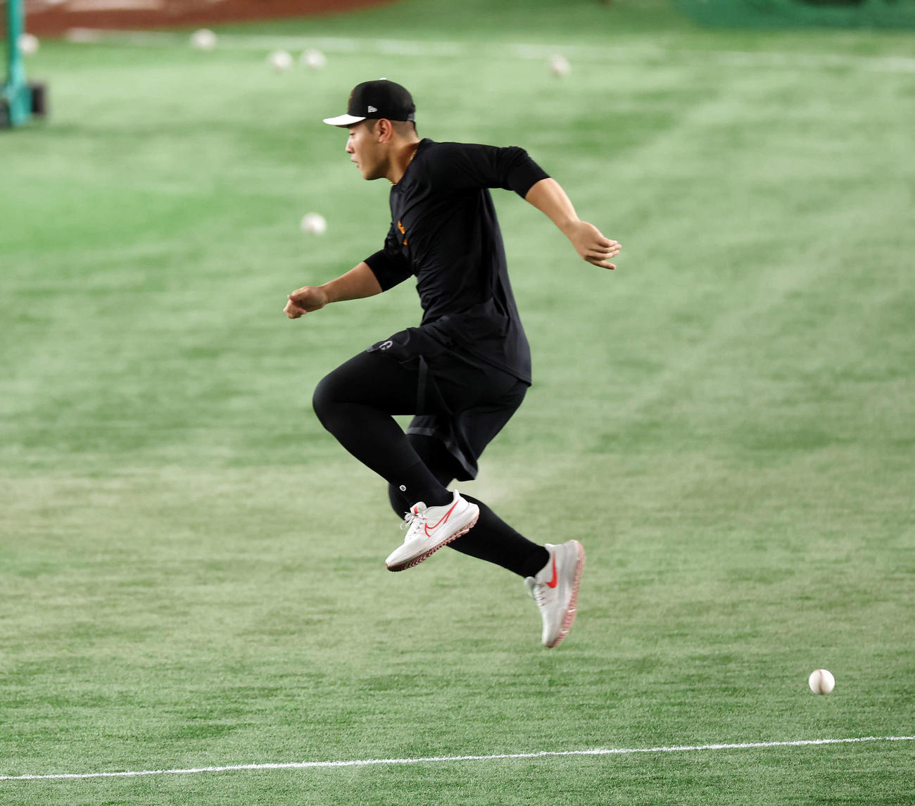 巨人対日本ハム　試合前、飛んできた打球を飛んで避ける巨人岡本和（撮影・宮地輝）