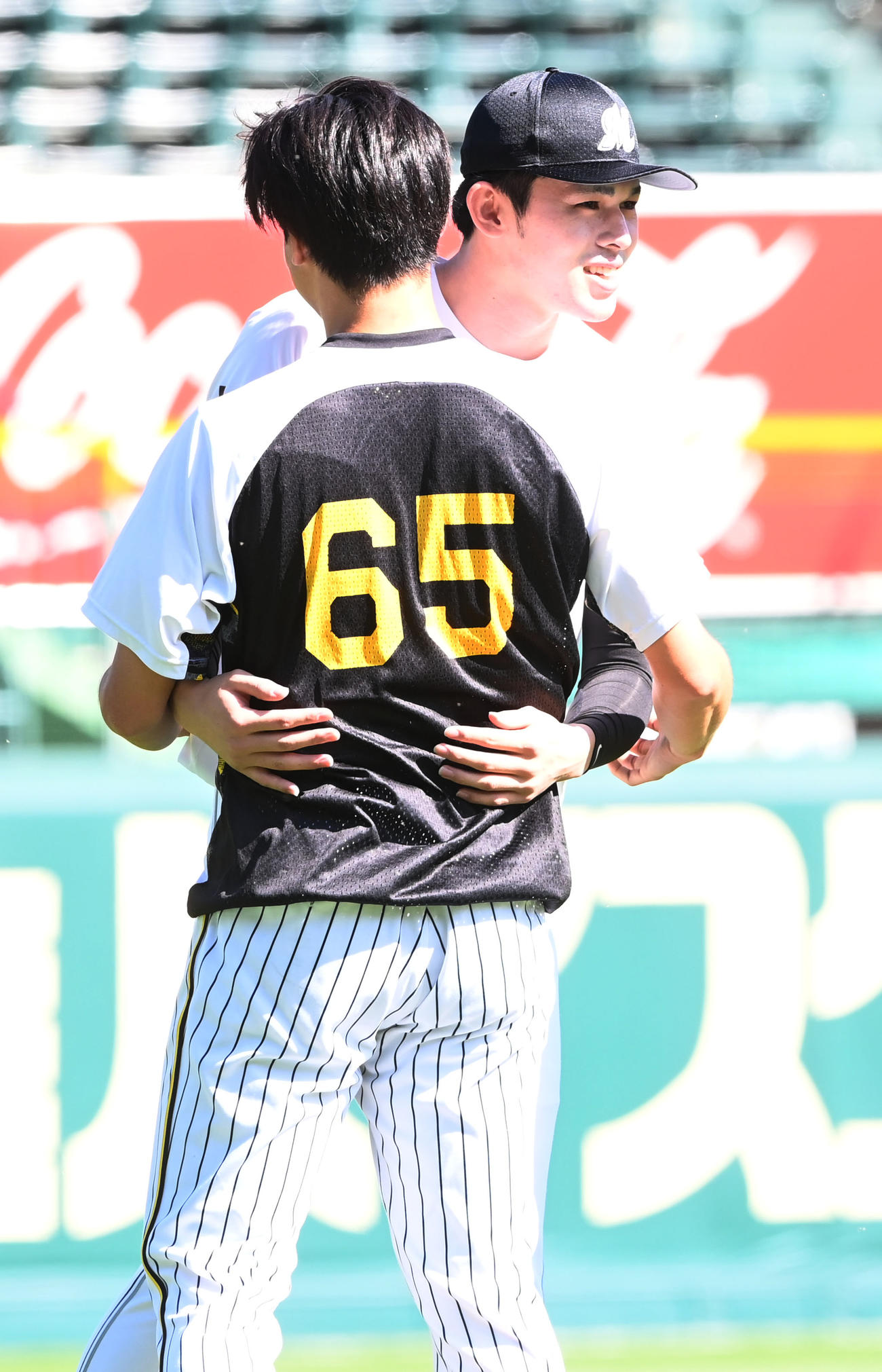 阪神対ロッテ　再会を果たし抱き合う阪神湯浅（左）とロッテ佐々木朗（撮影・和賀正仁）