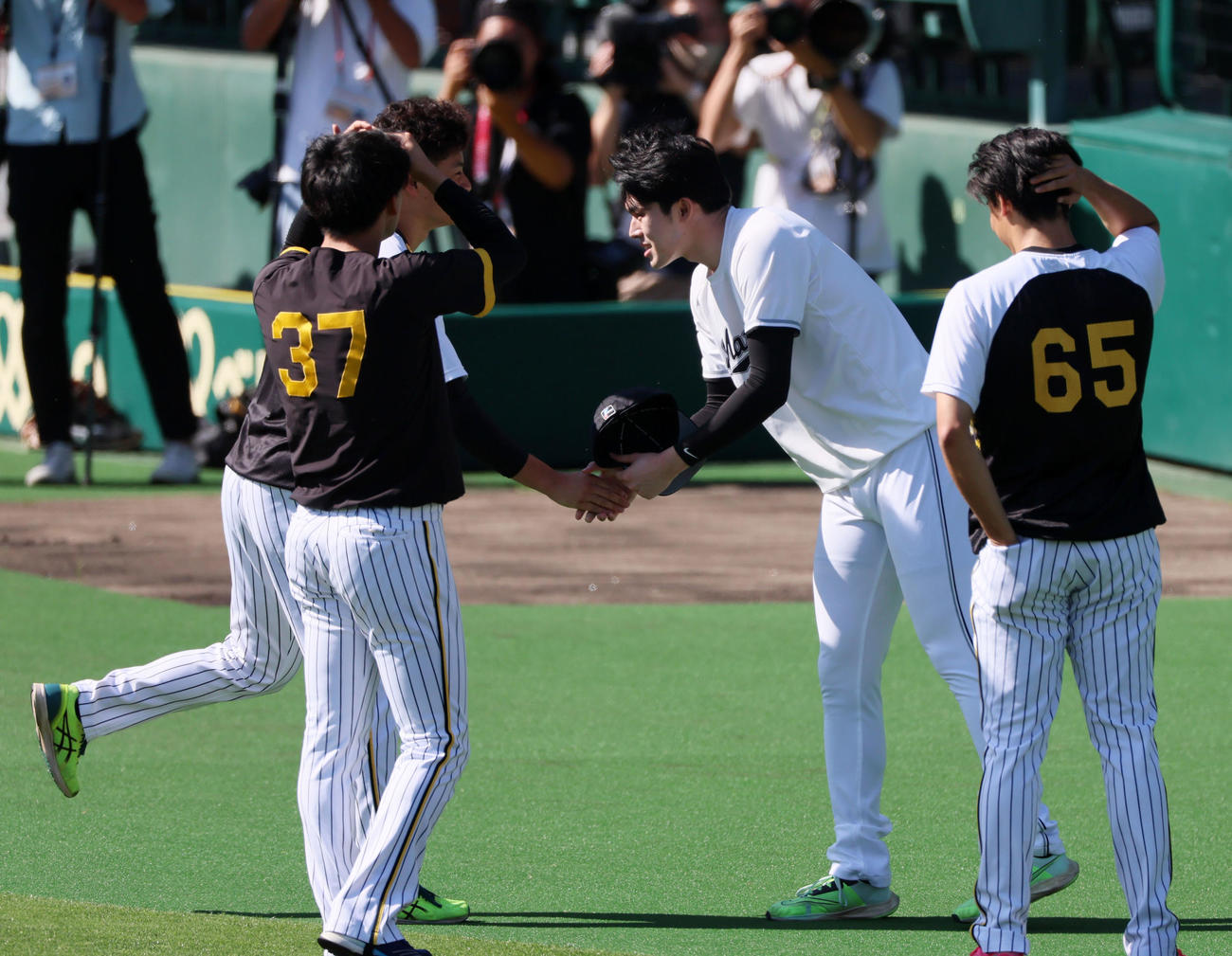 阪神対ロッテ　大竹（左から2人目）は佐々木朗とあいさつ。左端は及川、右は湯浅（撮影・加藤哉）