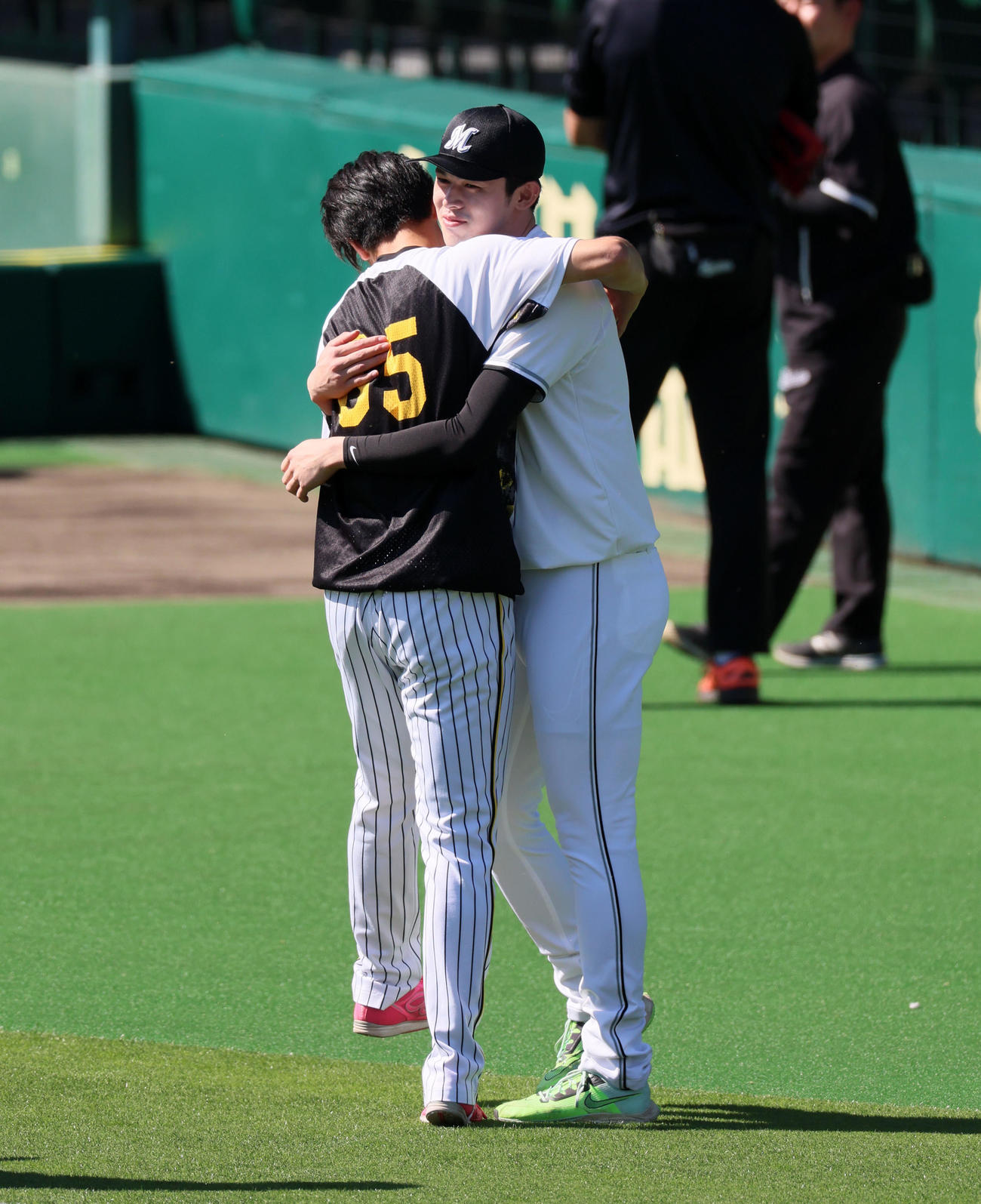 阪神対ロッテ　練習中の湯浅（左）は佐々木朗と抱き合って再会を喜んだ（撮影・加藤哉）