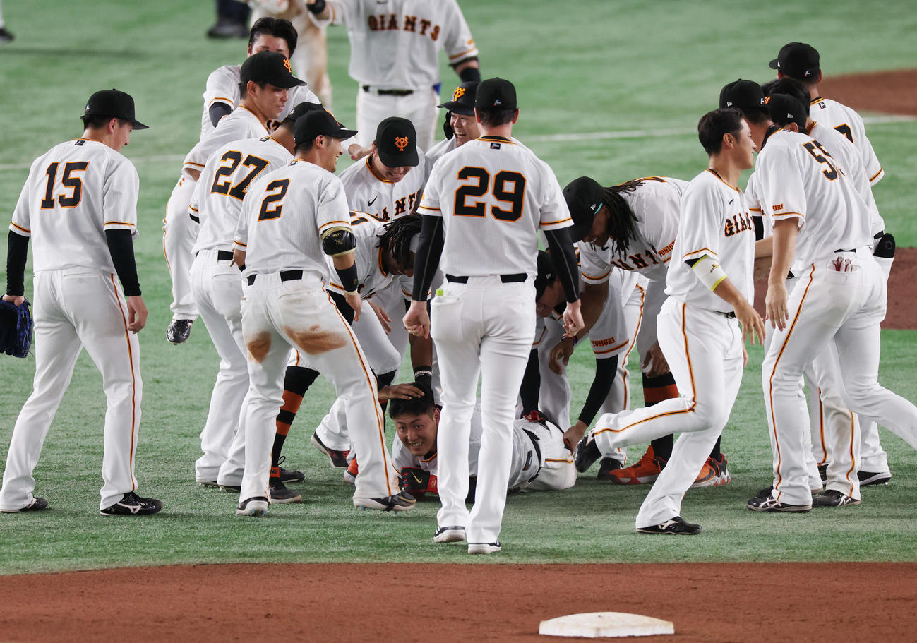 巨人対日本ハム　10回裏巨人無死一塁、サヨナラ左適時二塁打を放った岡本和（中央下）はチームメートの祝福に笑顔（撮影・宮地輝）