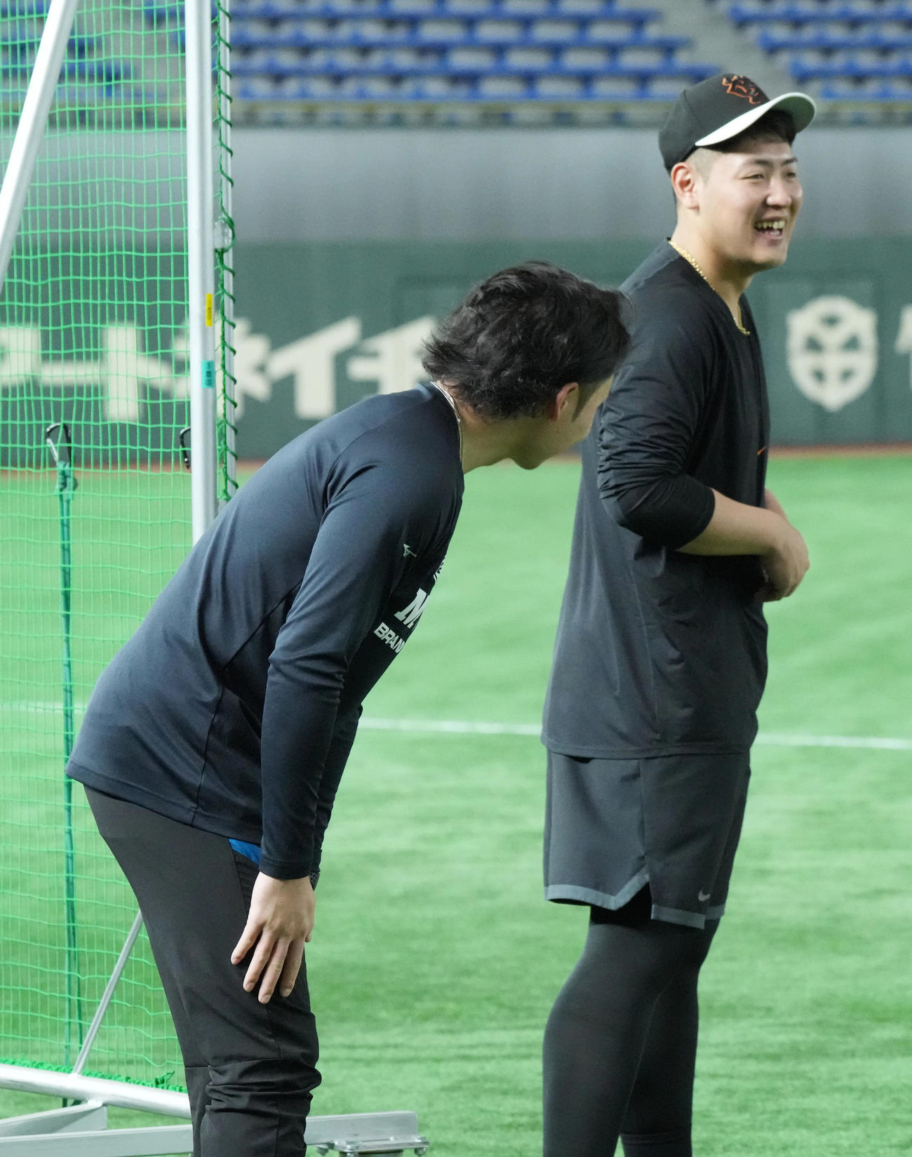 巨人対日本ハム　試合前の練習で談笑する巨人岡本和（右）と日本ハム伊藤（撮影・小沢裕）