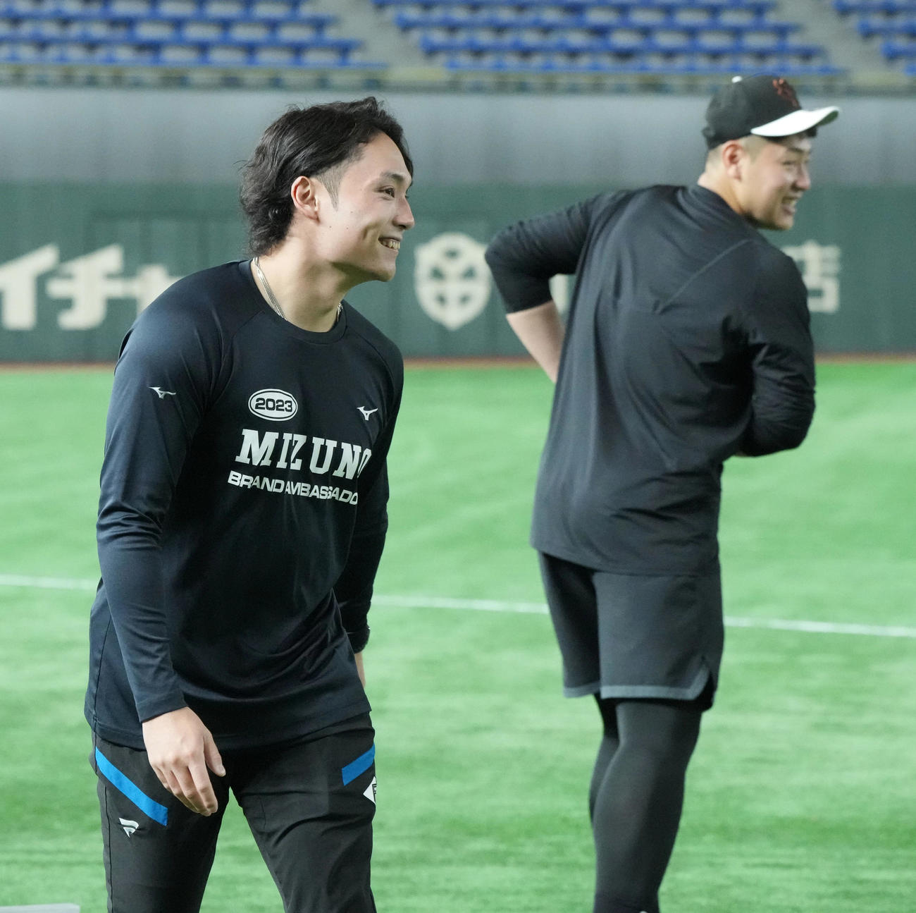 巨人対日本ハム　試合前の練習で談笑する巨人岡本和（右）と日本ハム伊藤（撮影・小沢裕）