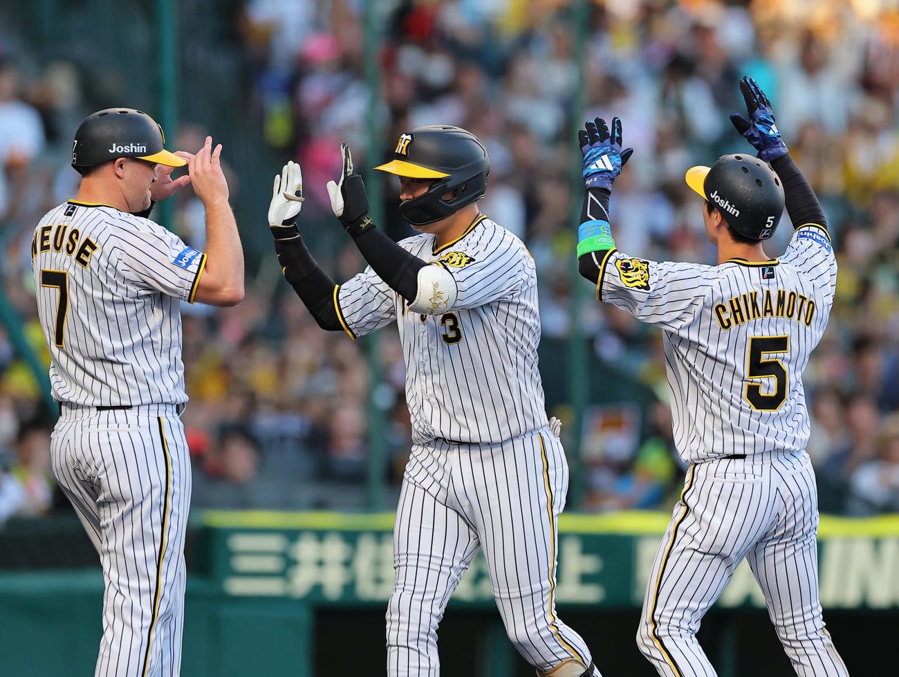 阪神対ロッテ　1回裏阪神1死一、二塁、中越え先制3点本塁打を放った大山（中央）はノイジー（左）近本の出迎えを受ける（撮影・上田博志）