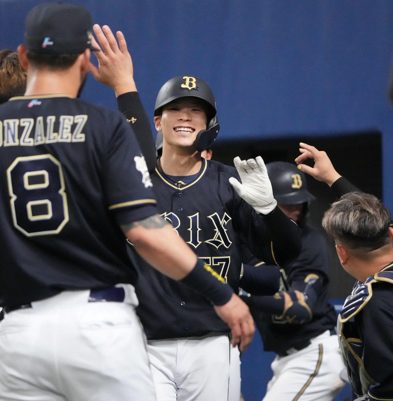 中日対オリックス　7回表オリックス2死二、三塁、中川圭（中央）は広岡の中前2点適時打で生還しナインとタッチを交わす（撮影・森本幸一）