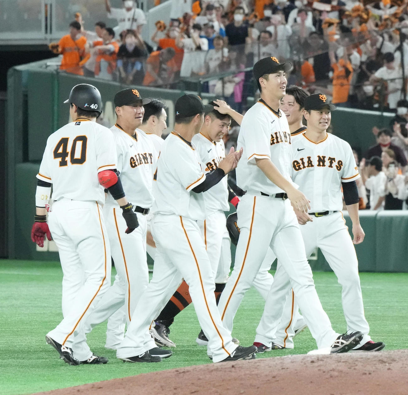 巨人対日本ハム　延長10回裏巨人無死一塁、サヨナラの左適時二塁打を放った巨人岡本和（中央）は歓喜のナインから手荒い祝福を受け、坂本（右から2人目）から頭をなでられる（撮影・小沢裕）