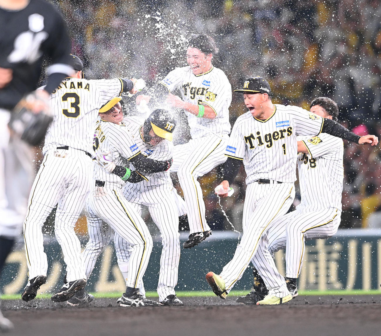 阪神対ロッテ　11回裏阪神1死満塁、中前にサヨナラ打を放った小幡（中央）はナインから歓喜のウオーターシャワーを浴びる（撮影・和賀正仁）