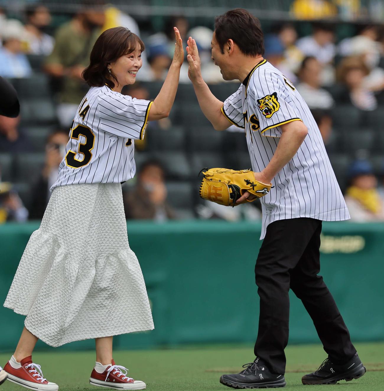 阪神対ロッテ　ファーストピッチセレモニーで華麗な投球を見せた声優の高木渉（右）と笑顔でハイタッチをする日高のり子（撮影・上田博志）