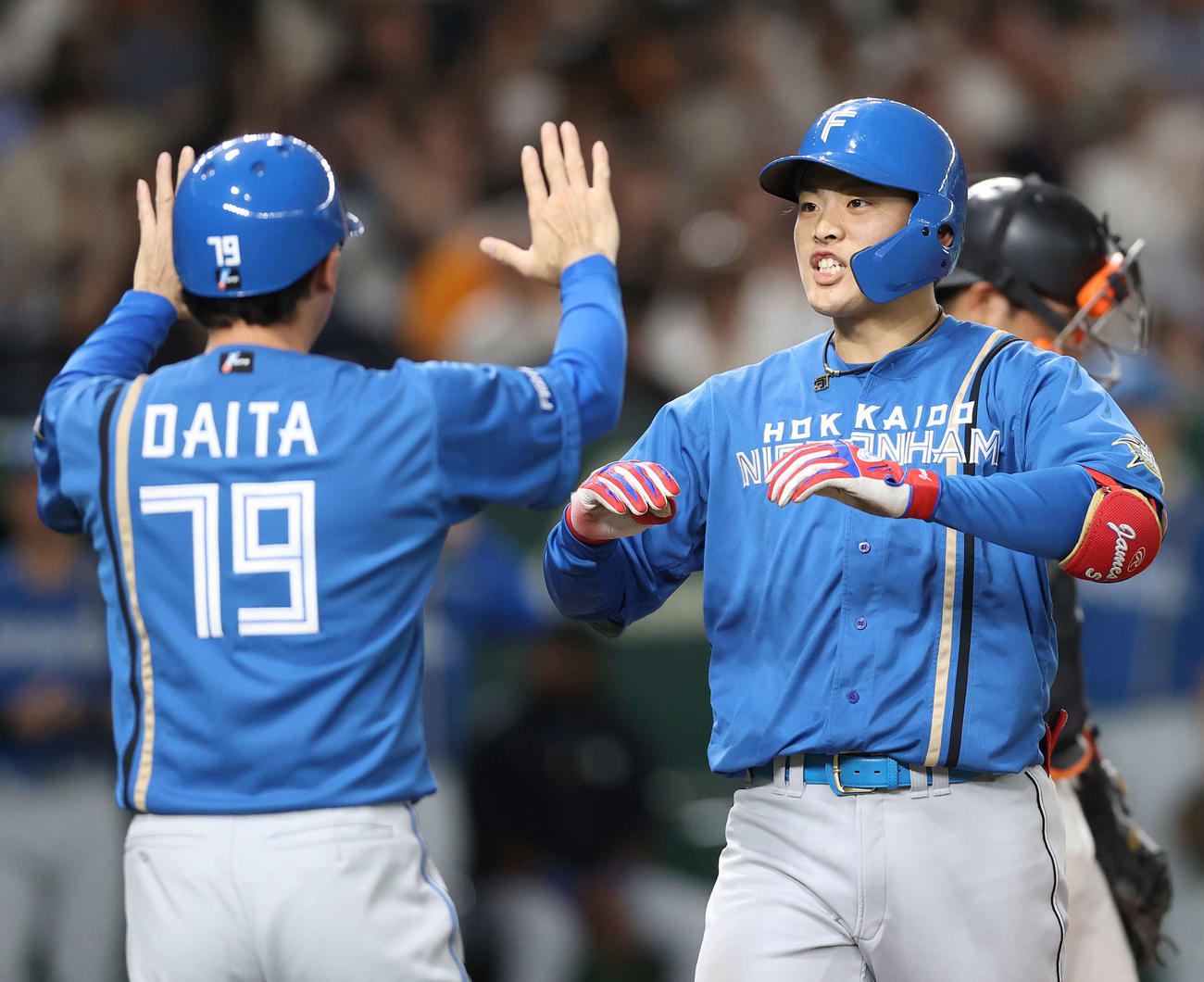 巨人対日本ハム　3回表日本ハム2死一、二塁、左越え3点本塁打を放った野村（右）は代田コーチに迎えられる（撮影・河野匠）