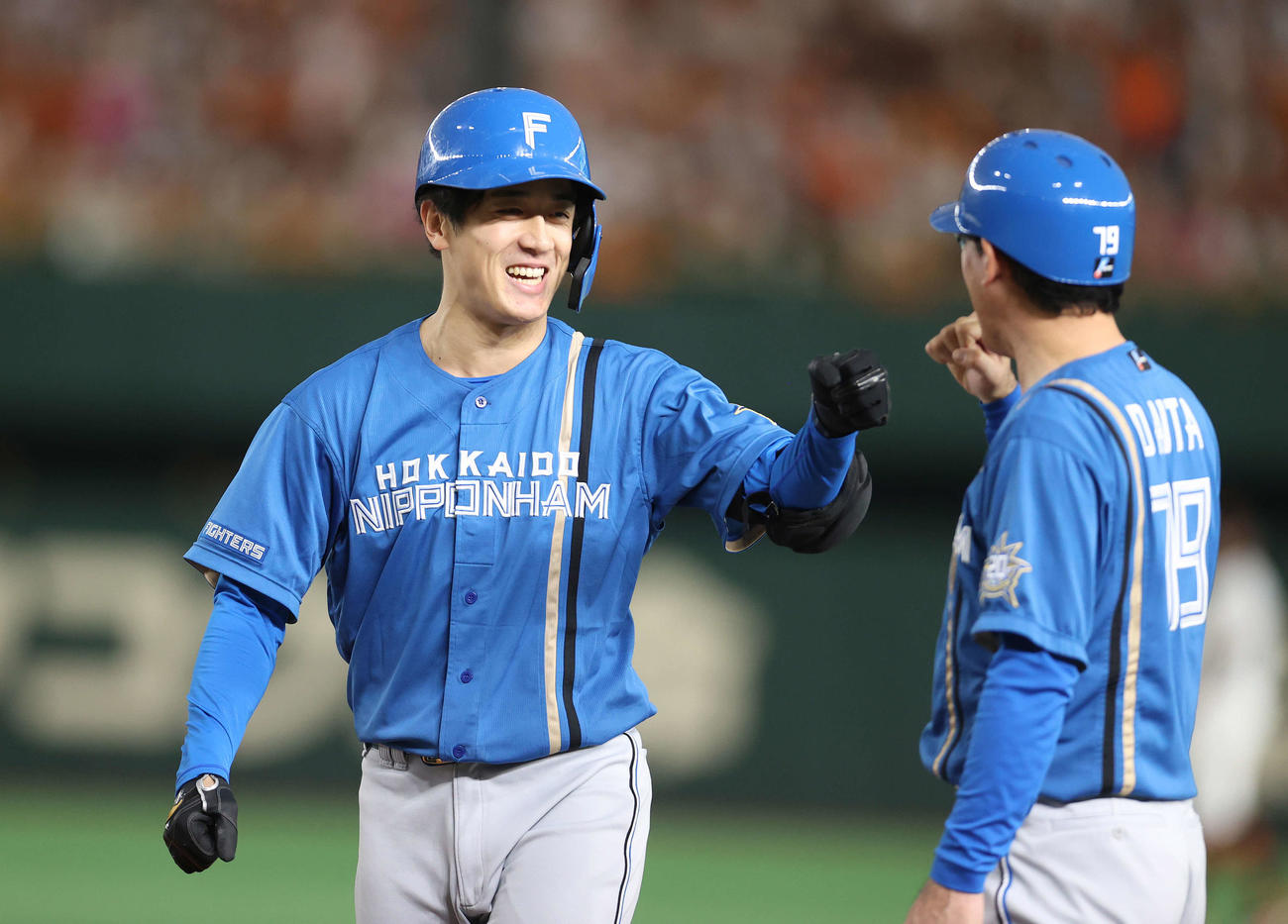 巨人対日本ハム　2回表日本ハム2死一、二塁、左前に適時打を放ち代田コーチ（右）とタッチを交わす北山（撮影・河野匠）
