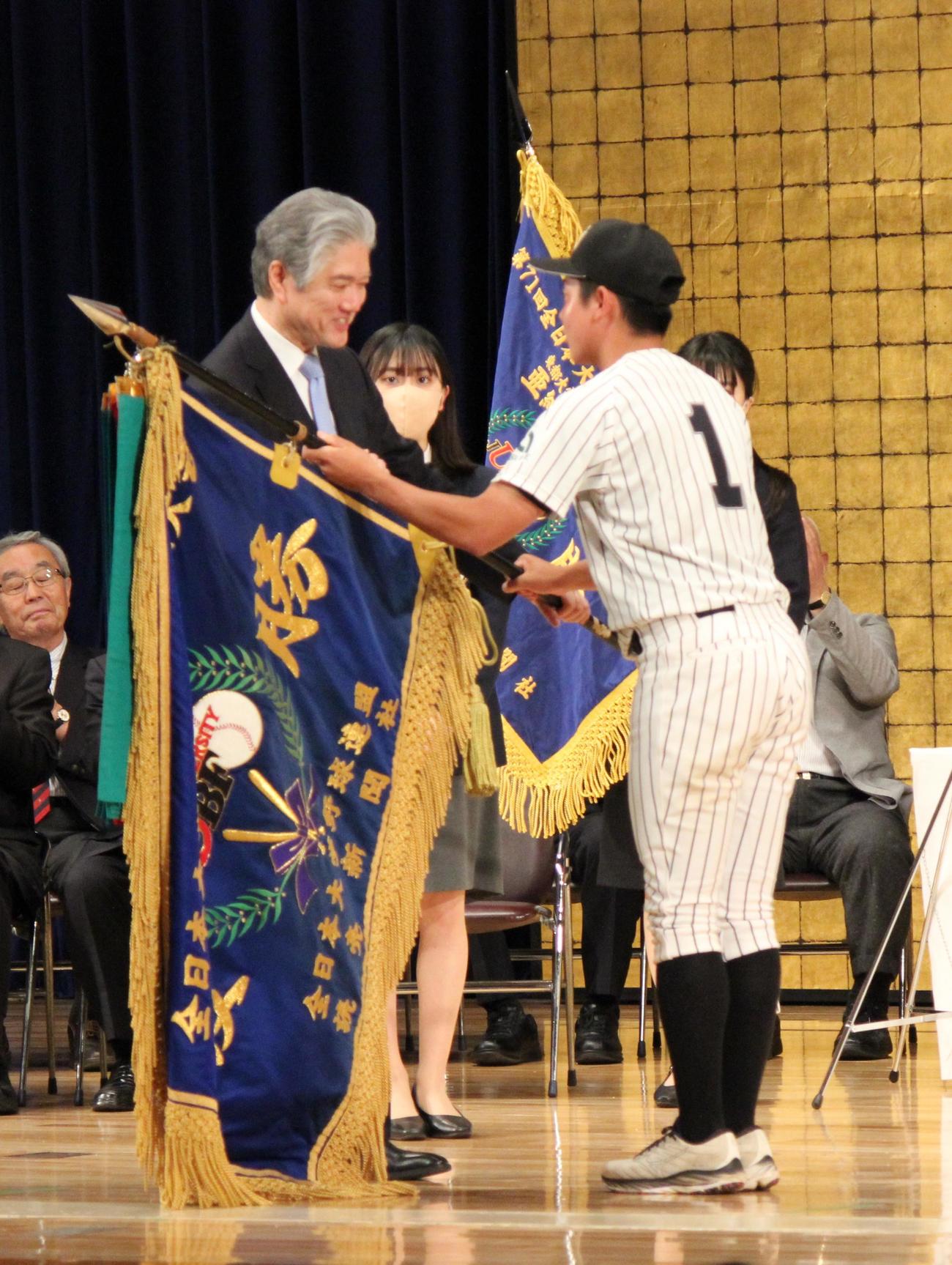 全日本大学野球選手権の開会式で優勝旗を返還する亜大・松浦隆己主将（撮影・柏原誠）