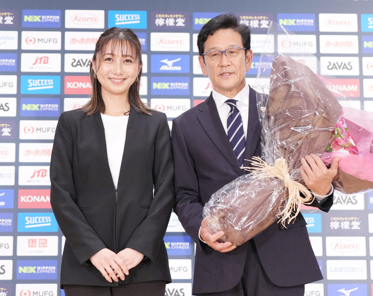 退任会見の最後にTBS近藤夏子アナウンサー（左）から花束を受け取り、記念撮影をする侍ジャパン栗山監督（撮影・狩俣裕三）