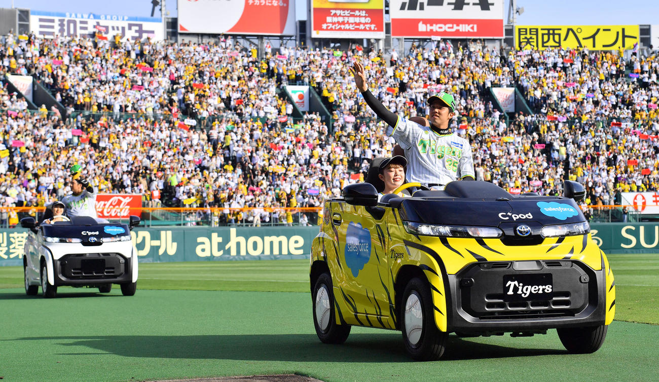 阪神対ロッテ　リリーフカーの乗りファンに手を振る阪神才木（右）と梅野（撮影・和賀正仁）