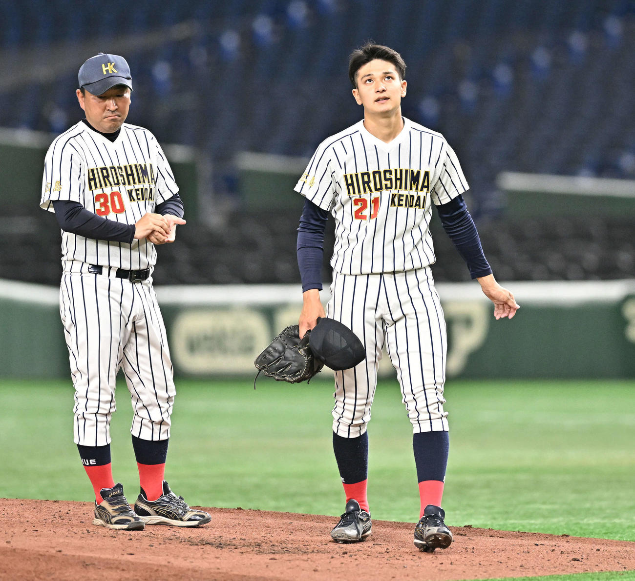 国際武道大対広島経大　3回表、追加点を奪われ降板する広島経大先発の倉本（右）（撮影・滝沢徹郎）