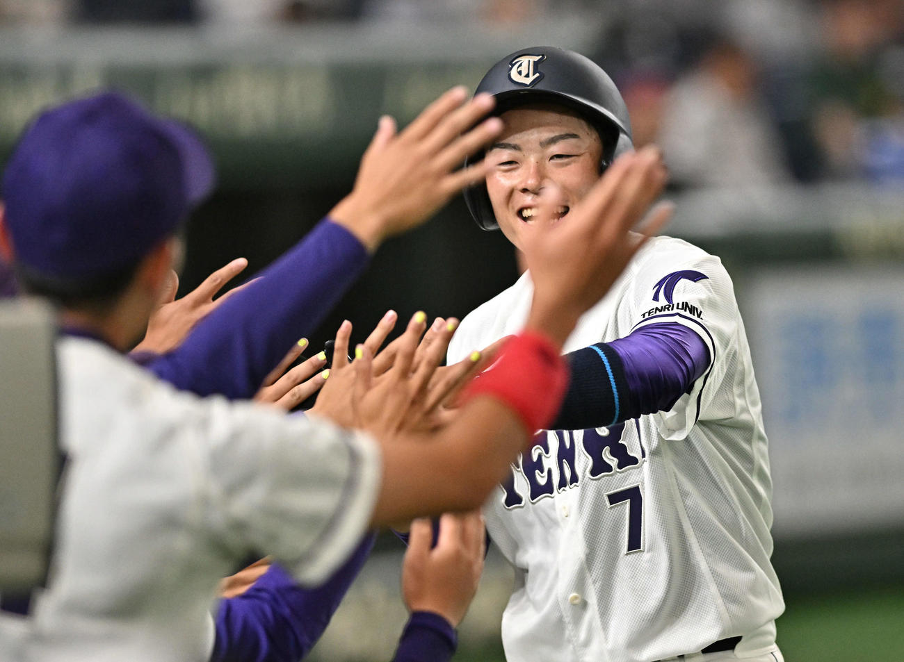 西南学院大対天理大　4回裏天理大1死三塁、近藤の先制右前適時打から生還した吉田元はチームメートとタッチをかわす（撮影・滝沢徹郎）