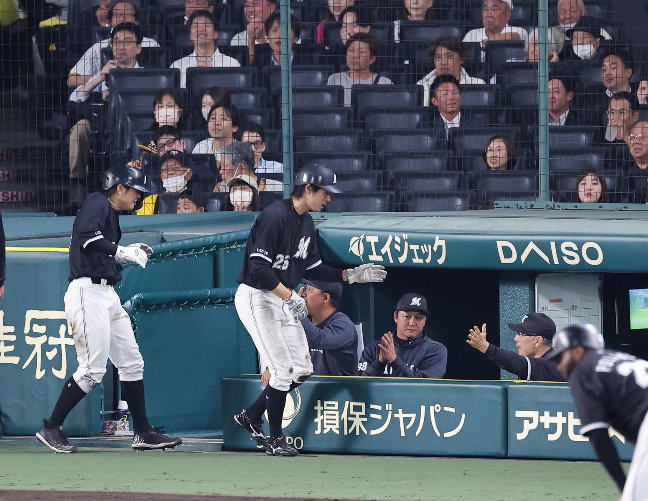 阪神対ロッテ　5回表ロッテ2死満塁、山口の2点打で生還した岡らを出迎える吉井監督（奥右端）（撮影・藤尾明華）